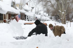 Mark Petrik and Dennis Smith dig out their south Buffalo driveway on Saturday, in Buffalo, N.Y. A new study found that Americans are more willing to adapt to extreme weather events, such as the record snowfall that buried Buffalo last week, than take steps to curb climate change.  Credit: Mike Groll/AP