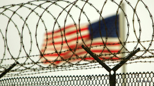 In this photo reviewed by US military officials, an American flag waves within the razor wire-lined compound of Camp Delta prison, at the Guantanamo Bay U.S. Naval Base, Cuba on Tuesday, June 27, 2006. The Supreme Court this week is expected to rule on the legality of President Bush's decision to create U.S. military tribunals for the detainees at Guantanamo, the first such tribunals since World War II.  Credit: AP Photo/Brennan Linsley